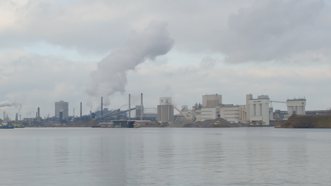 Lapso de tiempo de humo saliendo de un edificio industrial cerca de un río