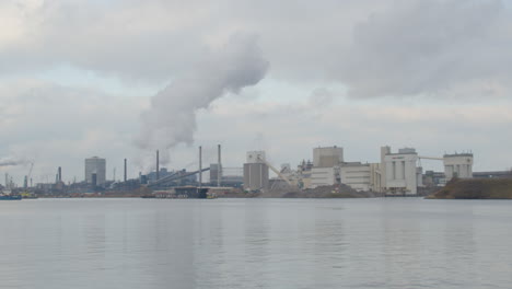 Time-lapse-of-smoke-rising-from-industrial-building-near-river