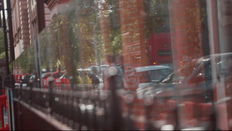 focus pull from gate to glass reflection of two men walking down the a city street in summer