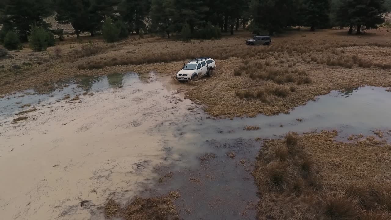 coche todoterreno blanco cruzando un charco y salpicando agua
