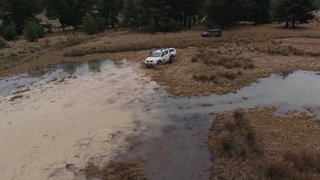 white offroad car crossing puddle ans splashes water