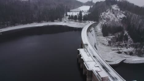 water retention dam with hydroelectric power plant in winter with freshly fallen snow in the morning