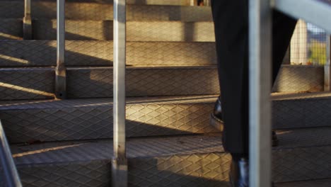 person walking up metal stairs