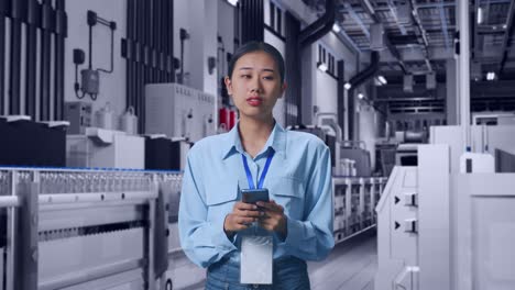 asian female with her smarphone with water production in bottling factory, she observes by looking around before she come to concentrating with her smarphone