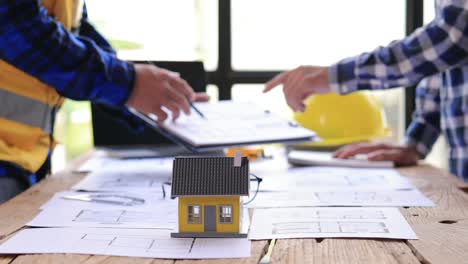 team of architects working on a sketch of the project in office. designers developing drawings, builders discussing blueprints. mortgage loan engineer, house, industry, project, design, 4k side view.