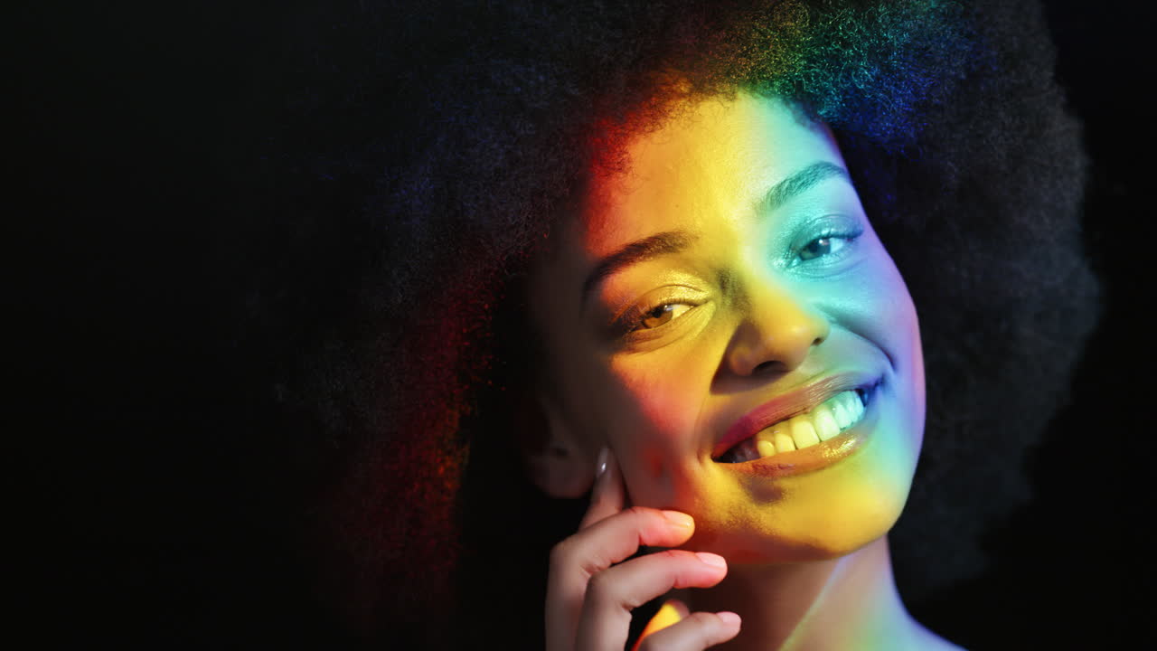 retrato multicolor mujer hermosa con afro funky sonriendo segura disfrutando de la expresión individual belleza femenina natural luz colorida sobre fondo negro concepto de orgullo lgbt