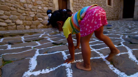 children playing a game on a stone street