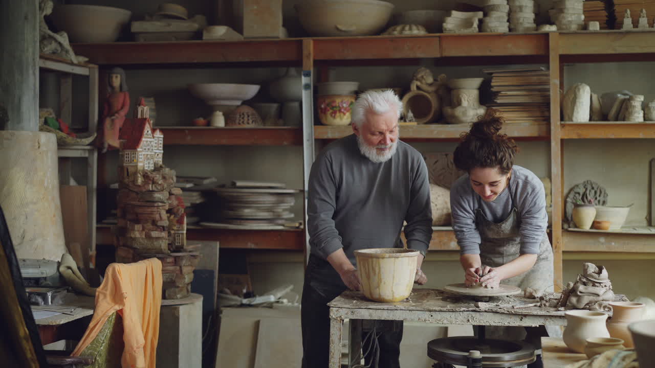 Senior and Young Artist Working Together in a Pottery Workshop