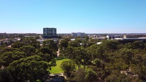 Vista-Aérea-Inversa-Sobre-Central-Park-Joondalup-Con-Edificios-De-La-Ciudad-En-El-Fondo