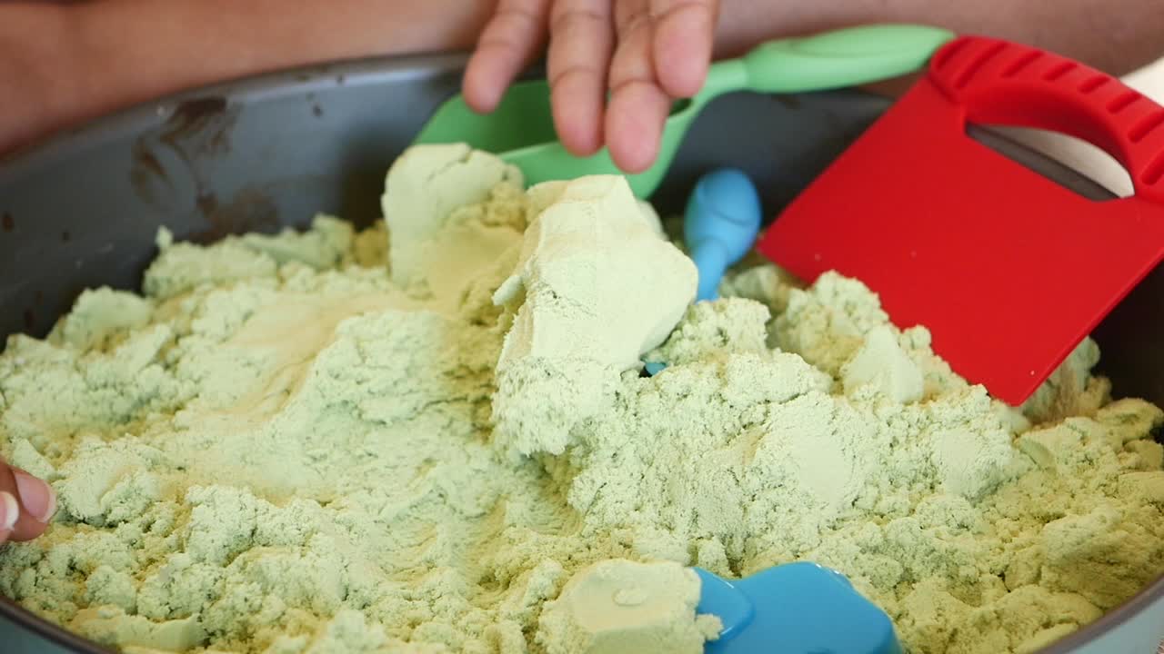 장난감 발으로 녹색 운동 모래의 근접