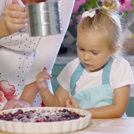 Adorable little girl engrossed in baking a pie