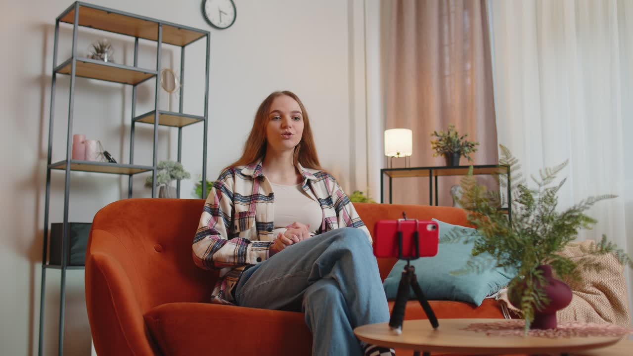 Girl blogger influencer taking selfie on smartphone make virtual social media video online at home