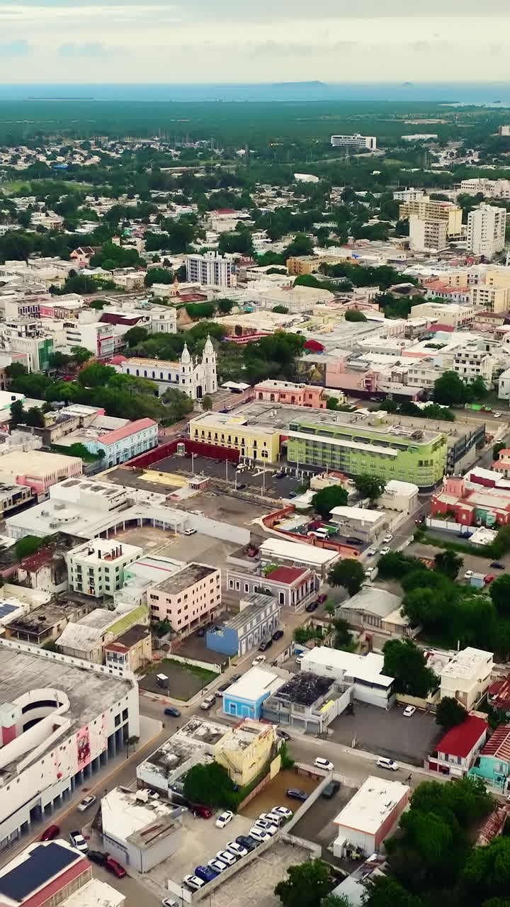 Città compatta con campanili bianchi, edifici colorati e parcheggi. Vista aerea del centro storico e della cattedrale a Ponce, Porto Rico. Video verticale.