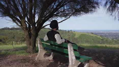 indian sikh man sitting on the bench in outdoor nature - push in