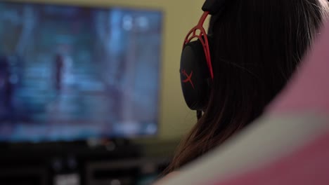 primer plano de una chica gamer, jugando en streaming, usando un auricular