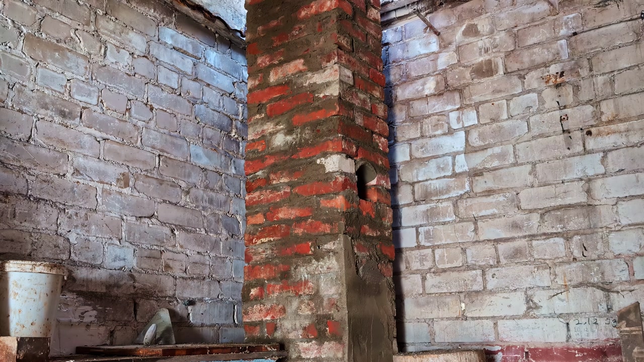 Unfinished brick chimney base in an old house interior during construction and home improvement works
