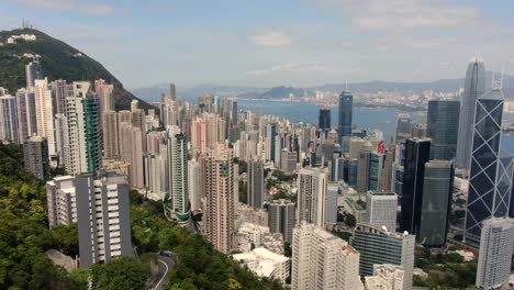 volar sobre la bahía central de hong kong y los rascacielos de la ciudad