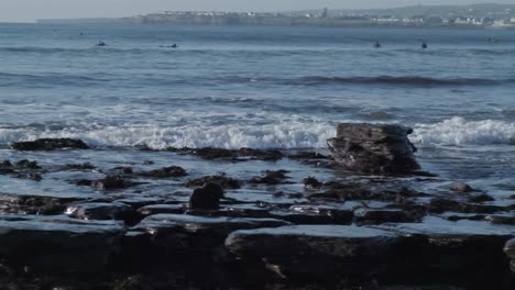 Weitwinkelaufnahme-Von-Wellen,-Die-An-Einem-Felsigen-Strand-In-Irland-Am-Lahinch-Beach-Auf-Einen-Felsen-Schlagen