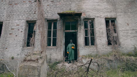 virologist in radioactive zone. man in protective suit in broken building. survivor holding flowers in hands in abandoned place. chemical attack.