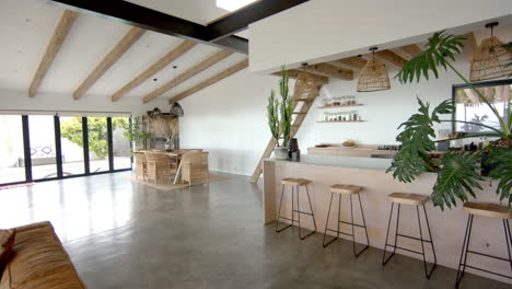 modern kitchen and living area with wooden beams and bar stools in home