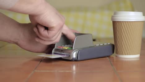 pago manual con tarjeta con taza de café para llevar plano medio