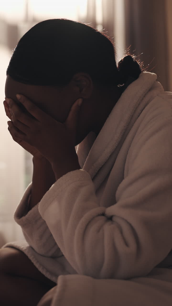 Mulher triste chorando e cobrindo o rosto com um roupão