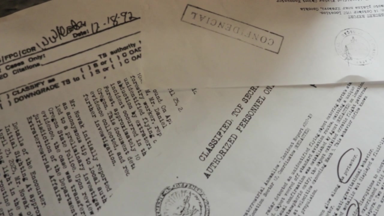 A slow slide shot unveils typewritten classified documents and police reports spread across a desk, suggesting hidden truths, investigation, and a deepening conspiracy narrative.