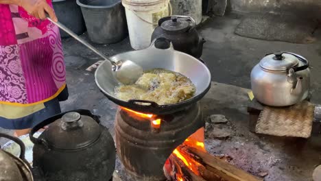 El-Proceso-De-Cocinar-Alimentos-Fritos-Como-Tofu,-Tempeh-En-Una-Sartén-Tradicional-Y-Una-Estufa-Usando-Carbones-Y-Una-Estufa