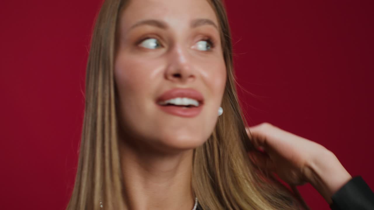 retrato de una mujer sonriente contra un fondo rojo