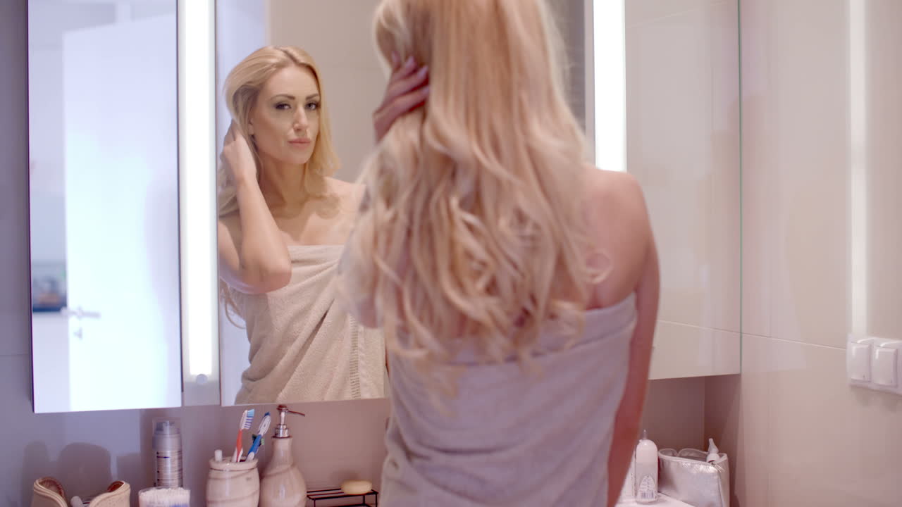 Donna che si guarda nello specchio del bagno