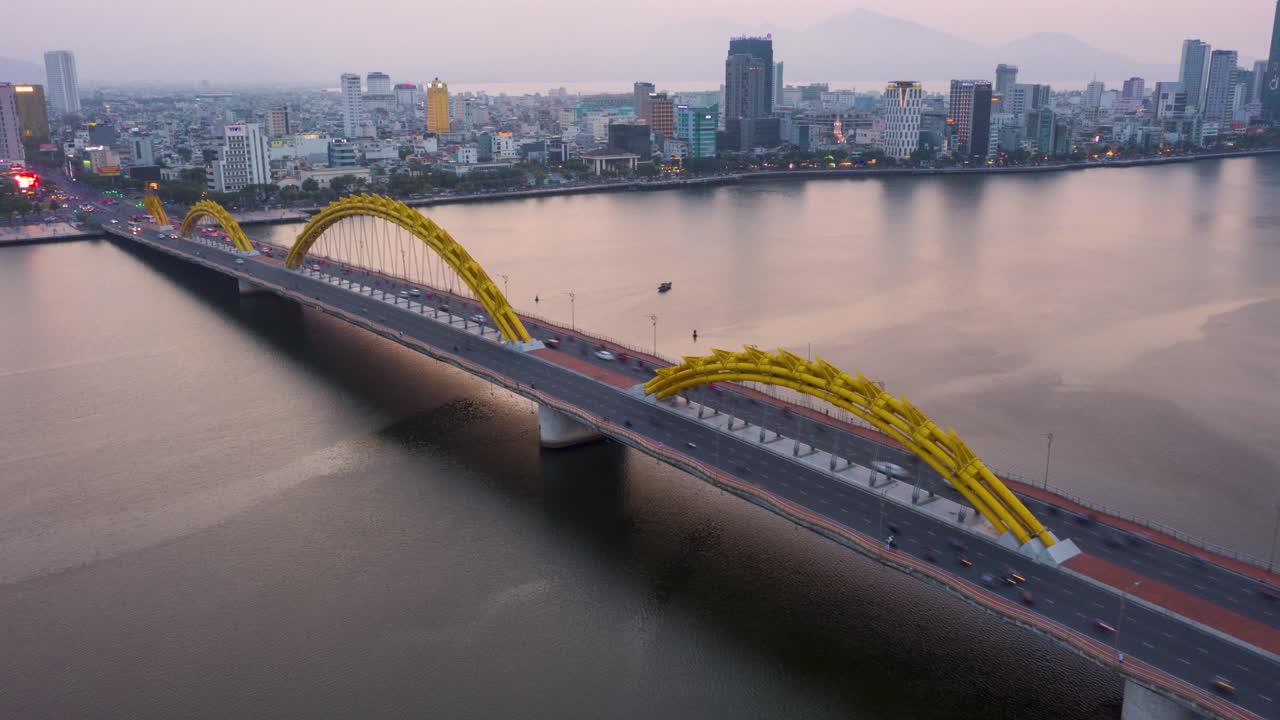impresionante hiperlapso aéreo colorido del emblemático puente del dragón cau rong, el tráfico y el horizonte de la ciudad cambiando colores durante la puesta de sol en danang, vietnam