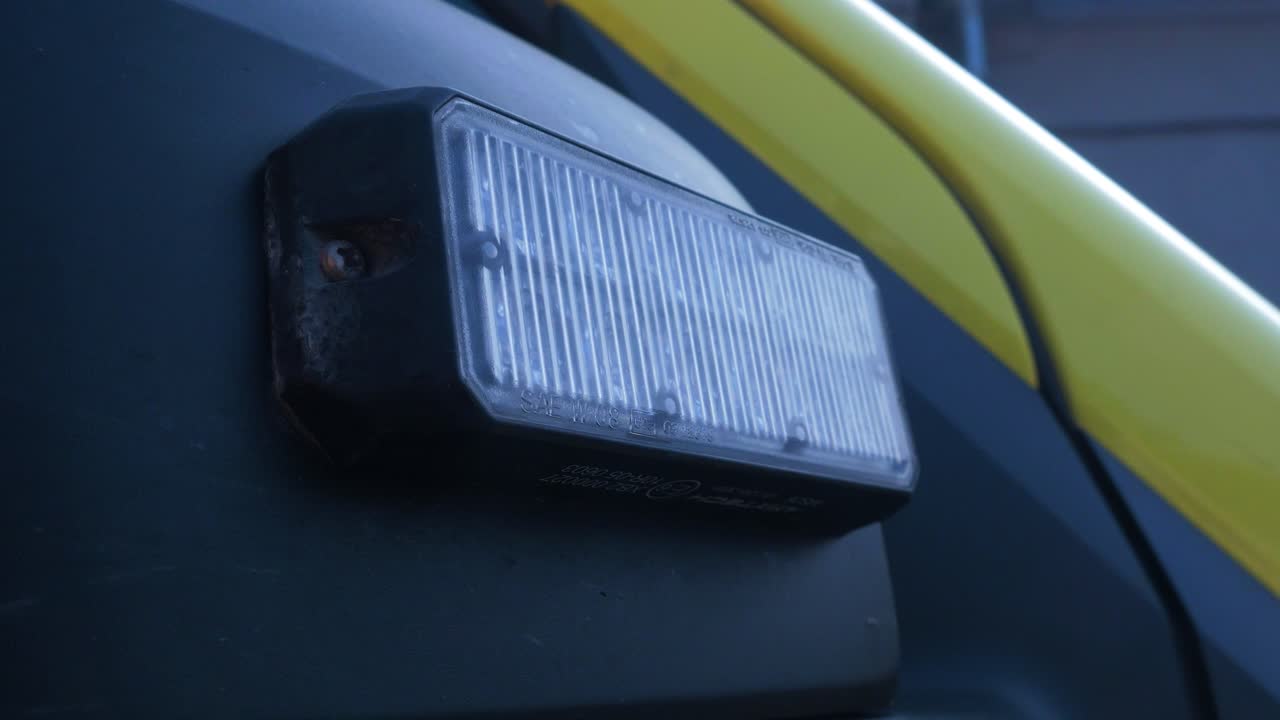 노란색 응급 구급차 차량의 외관, 파란색 깜박이는 경고등, 클로즈업 핸드헬드 샷