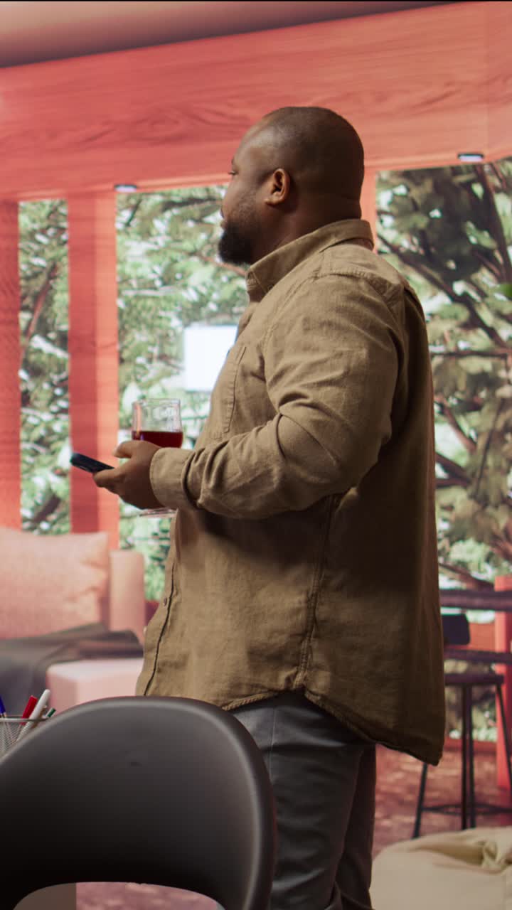 African American Man Browsing Smartphone and Holding Red Wine
