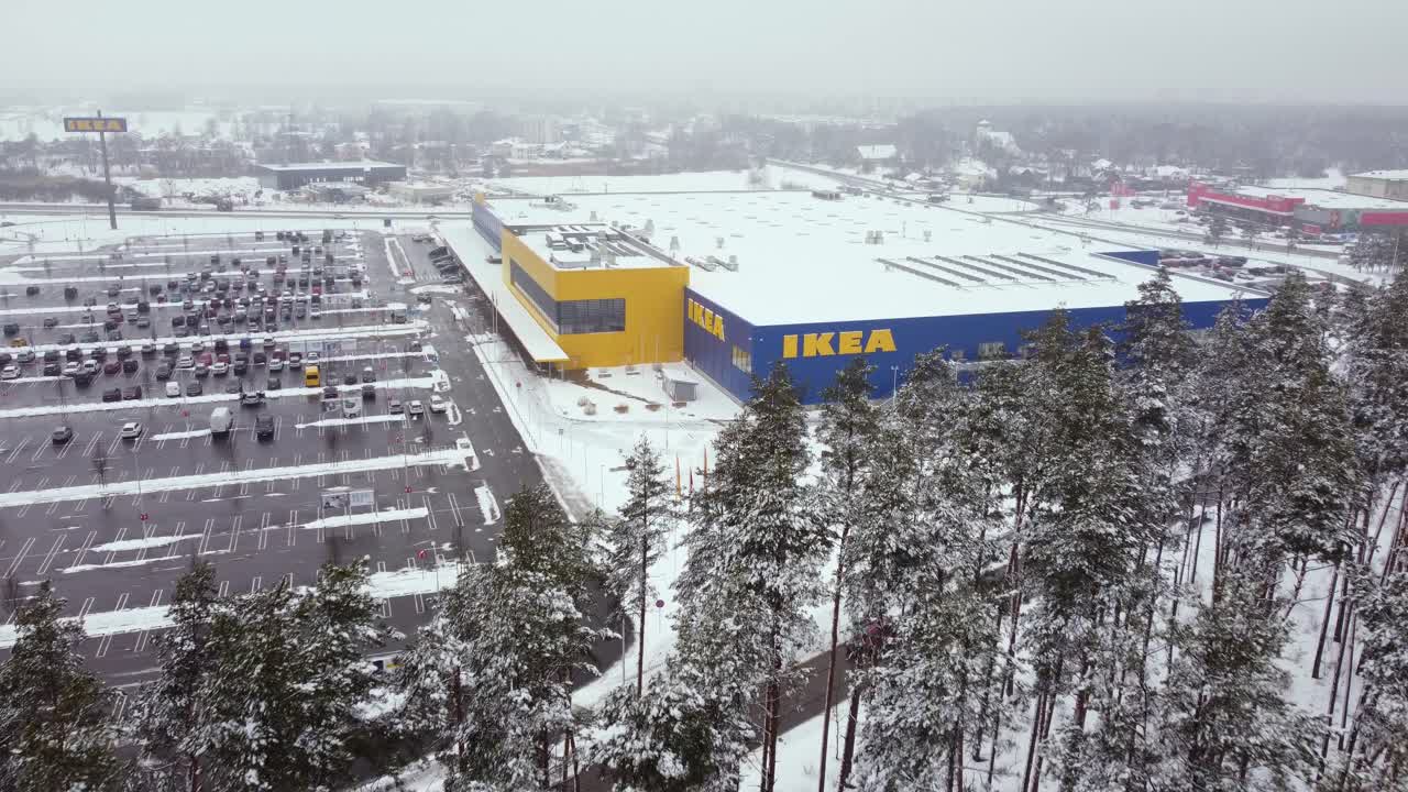 라트비아 리가에 있는 대형 도로 주차 공간이 있는 눈 덮힌 다중 체인점 건물을 특징으로 하는 조립 준비가 완료된 가구를 판매하는 세계 최대의 가구 소매업체 이케아의 조감도