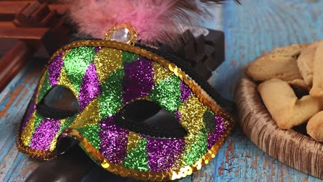 jewish carnival purim celebration on hamantaschen cookies, noisemaker and mask with parchment