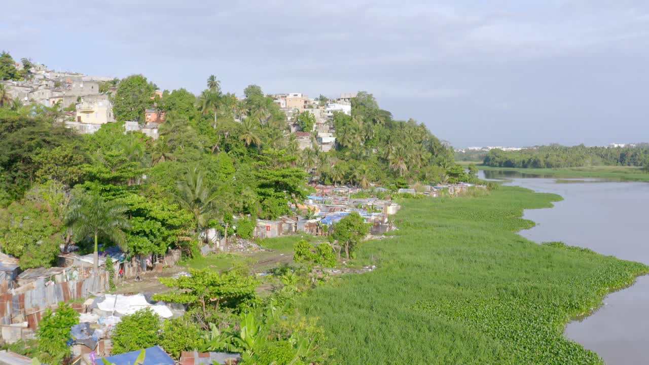 Aerial forward over slum on Ozama river banks, Santo Domingo