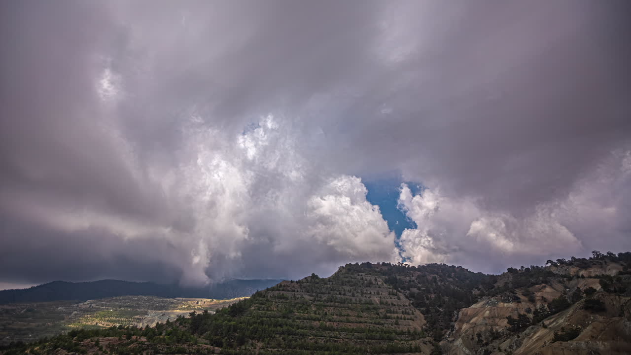nubes de cúmulo rodando sobre el paisaje montañoso.