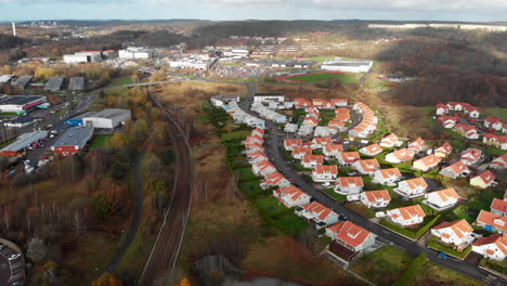 swedish suburbs real estate by railway, aerial drone flying forward on cloudy day