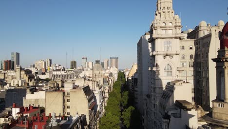 Cinematic-aerial-dolly-in-above-May-avenue-alongside-with-heritage-building-Barolo-Palace-in-downtown-Buenos-Aires-during-bright-daylight