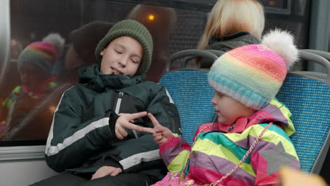 sister with elder brother playing rock scissors paper in the bus