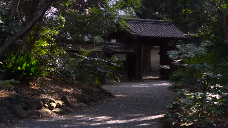 slow walk up to pathway inside japanese garden with gate at end