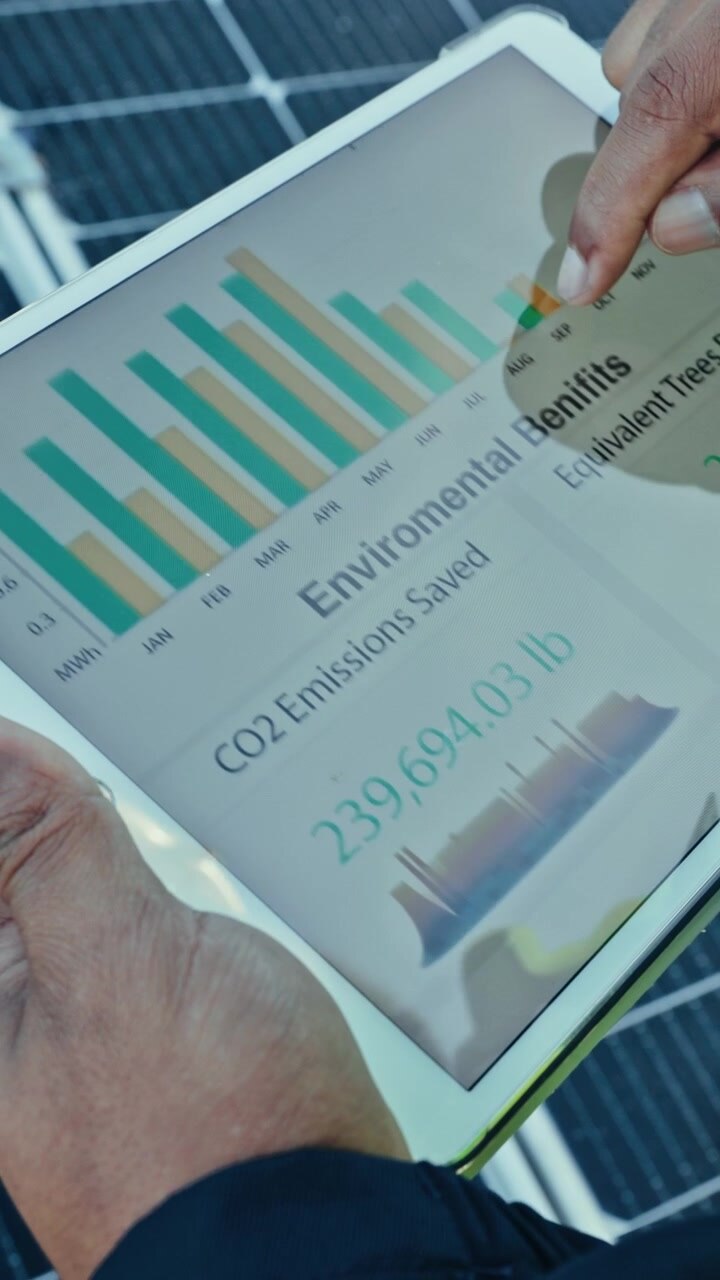 Tekniker der overvåger solenergiproduktion på tablet