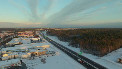 Carretera-Al-Atardecer-Con-Luces-De-La-Ciudad-Y-Paisajes-Nevados---Gdynia,-Polonia