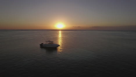 flying over the yacht in ocean at sunset
