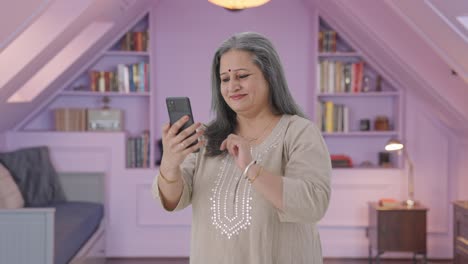 Happy-Indian-old-woman-scrolling-through-phone