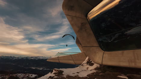 paragliding over mountainous modern architecture at sunset