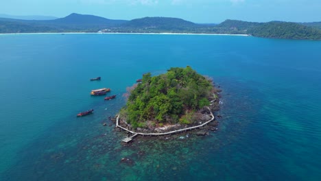 tourist boats surrounding tropical koh toch island near sihanoukville, cambodia. smooth aerial view flight panorama orbit drone
