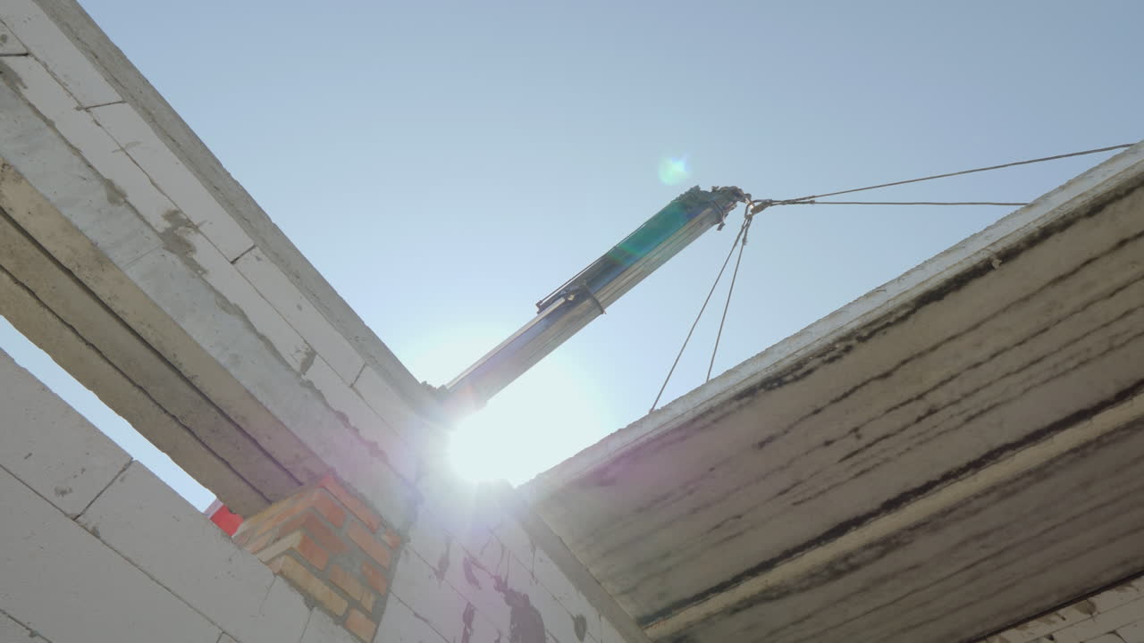 la pluma levanta una pesada losa de hormigón armado para su instalación en la base del piso