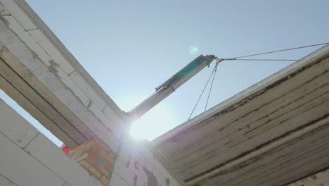 la pluma levanta una pesada losa de hormigón armado para su instalación en la base del piso