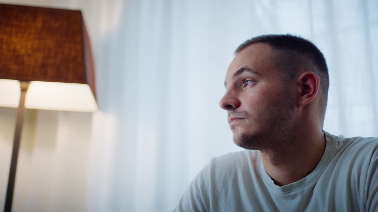 Portrait of a man looking up near a lamp